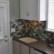 Laundry Room featuring glass tile backsplash